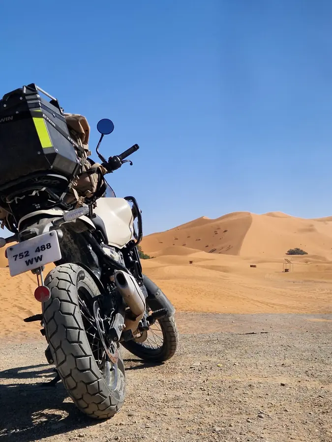 Adventure motorcycle beside the Moroccan dunes